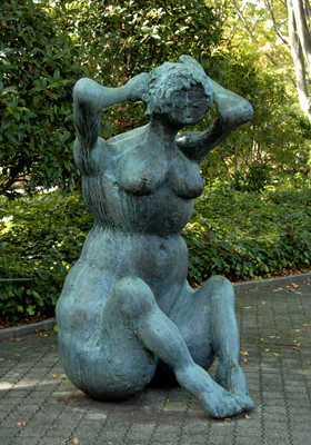 座り込み頭に手を当てる裸の女性の像の写真